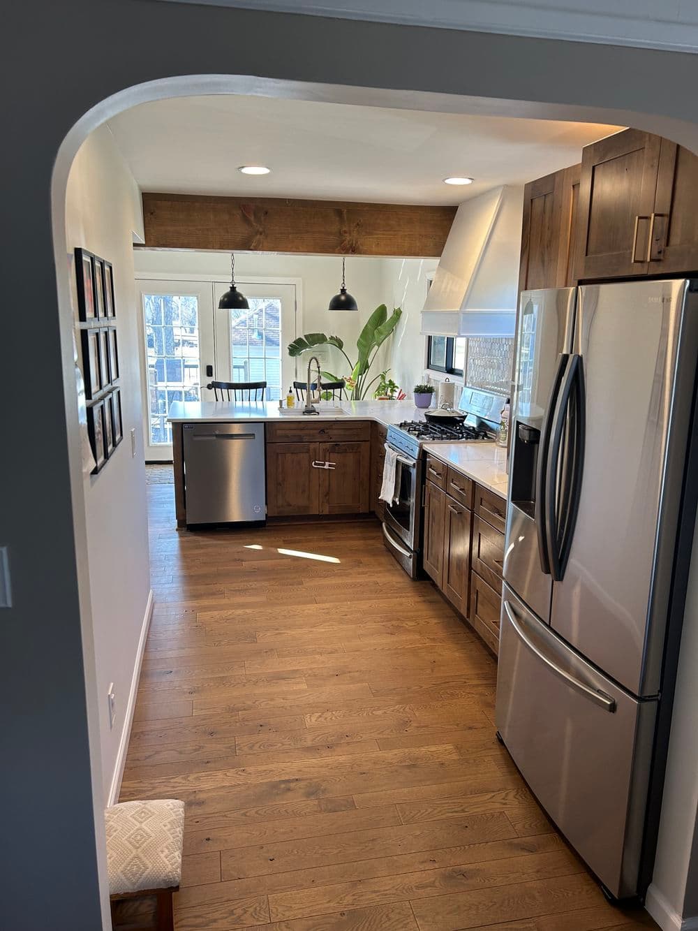 Modern kitchen featuring stainless steel appliances, wooden cabinets, and natural light.